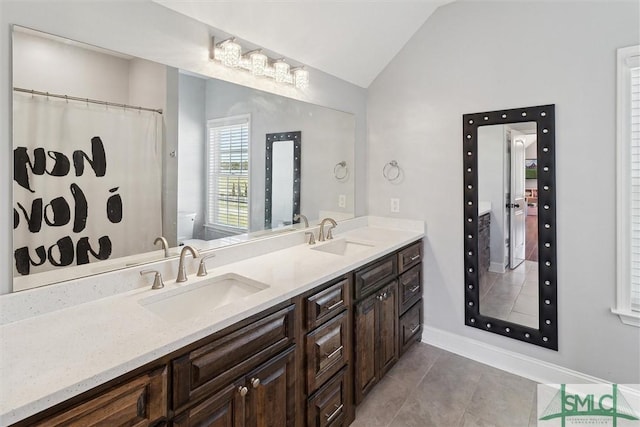 full bathroom with lofted ceiling, double vanity, a sink, and toilet