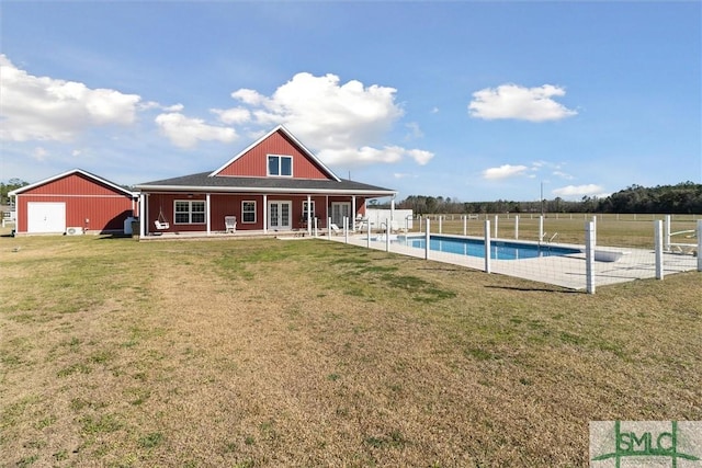 back of house with a fenced in pool, a patio, a lawn, fence, and french doors