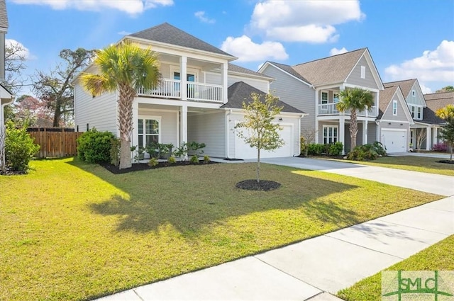 view of front of home with a garage, concrete driveway, a balcony, fence, and a front yard