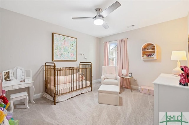 bedroom with light carpet, a nursery area, visible vents, and baseboards