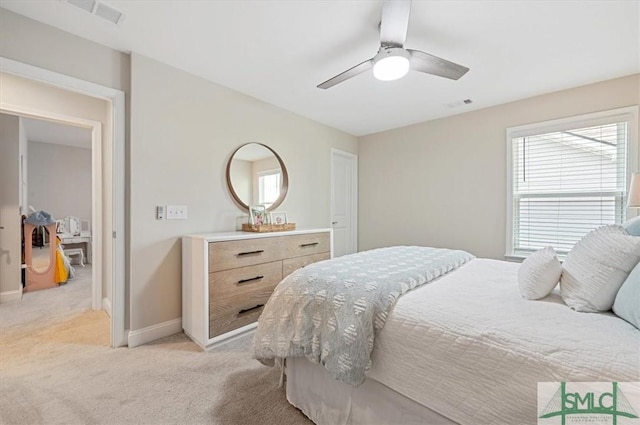 bedroom featuring a ceiling fan, light colored carpet, visible vents, and baseboards