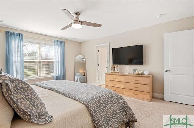 bedroom featuring light carpet, baseboards, and a ceiling fan