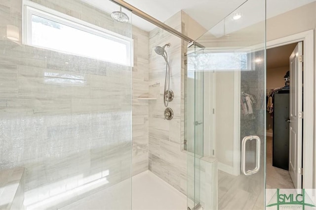 bathroom featuring a stall shower and a spacious closet