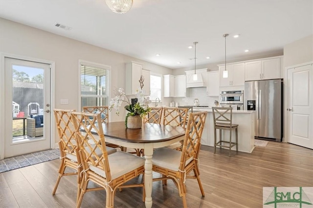 dining room featuring light wood-type flooring, visible vents, and recessed lighting