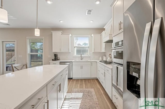 kitchen featuring light countertops, visible vents, appliances with stainless steel finishes, a sink, and light wood-type flooring