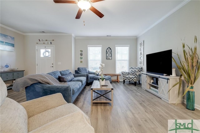 living area with light wood-type flooring, crown molding, baseboards, and ceiling fan