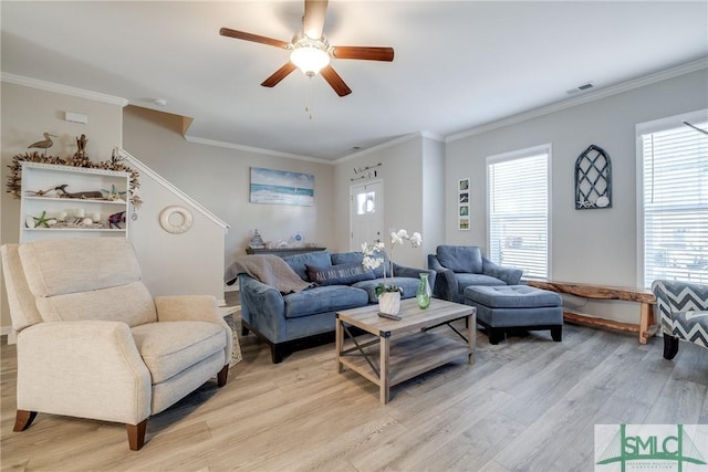 living area featuring light wood-style flooring, visible vents, ceiling fan, and crown molding