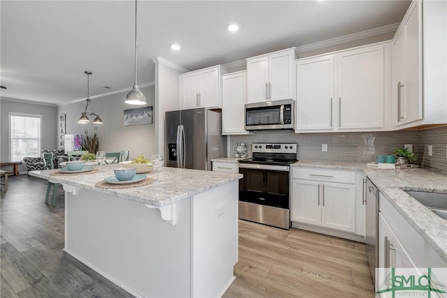 kitchen with white cabinetry, appliances with stainless steel finishes, tasteful backsplash, and ornamental molding