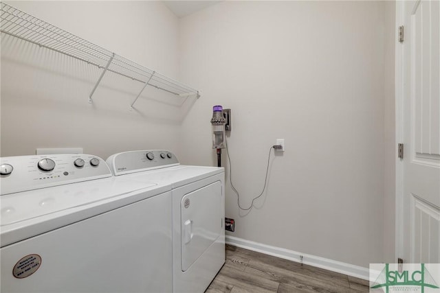 washroom with laundry area, baseboards, light wood finished floors, and washer and dryer