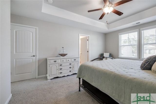 bedroom featuring baseboards, visible vents, a raised ceiling, a ceiling fan, and light colored carpet