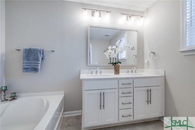 bathroom with double vanity, a garden tub, baseboards, and a sink