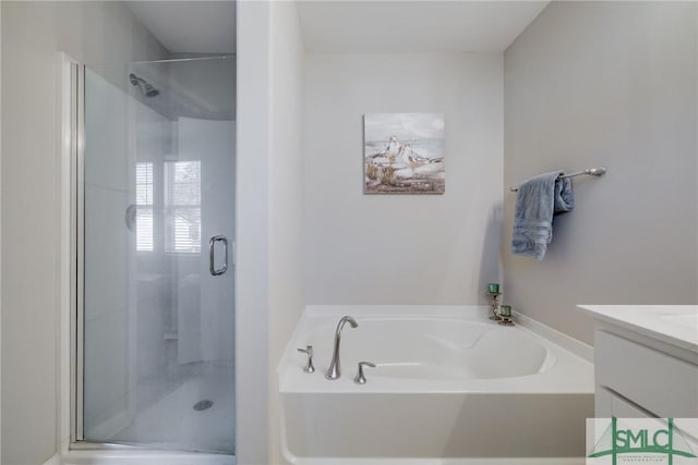 full bathroom with a garden tub, a shower stall, and vanity