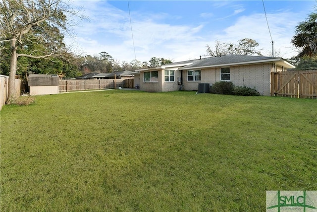 back of house featuring central air condition unit, a yard, and a fenced backyard