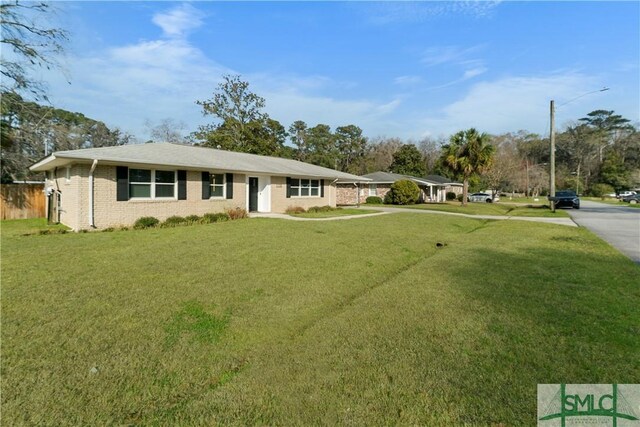 ranch-style house featuring brick siding and a front lawn