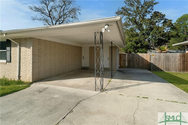 view of parking featuring a carport, driveway, and fence