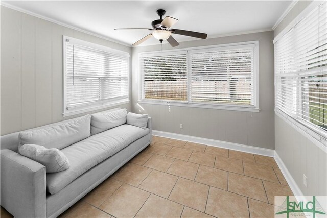 living area featuring ceiling fan, light tile patterned flooring, a wealth of natural light, and ornamental molding