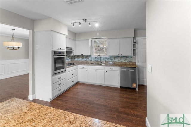 kitchen with dark wood-type flooring, a sink, tasteful backsplash, white cabinetry, and appliances with stainless steel finishes