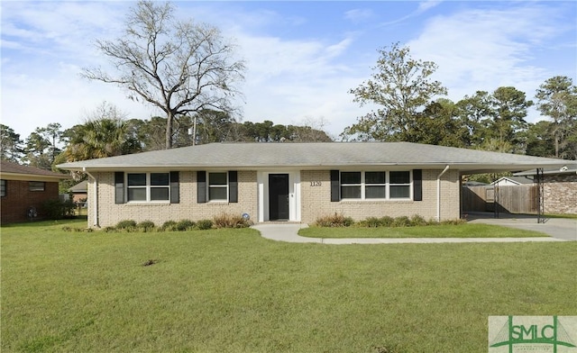 ranch-style home featuring brick siding, an attached carport, a front lawn, fence, and concrete driveway