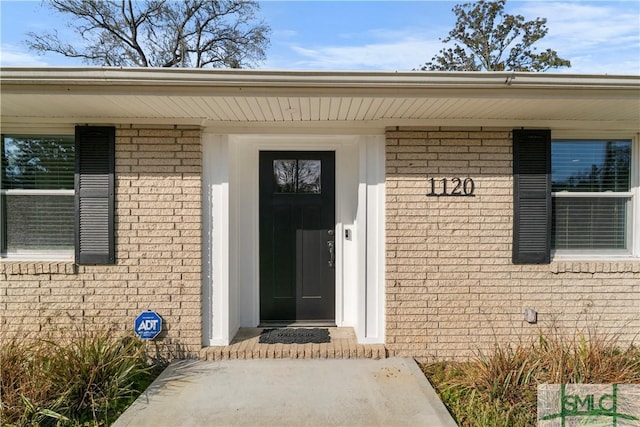 property entrance featuring brick siding