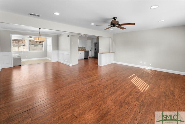 unfurnished living room with visible vents, ceiling fan, a wainscoted wall, recessed lighting, and dark wood-style floors