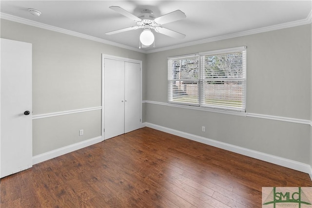 unfurnished bedroom featuring a closet, ornamental molding, baseboards, and wood finished floors