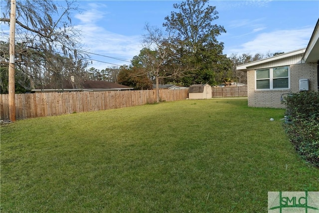 view of yard featuring an outbuilding, a shed, and a fenced backyard