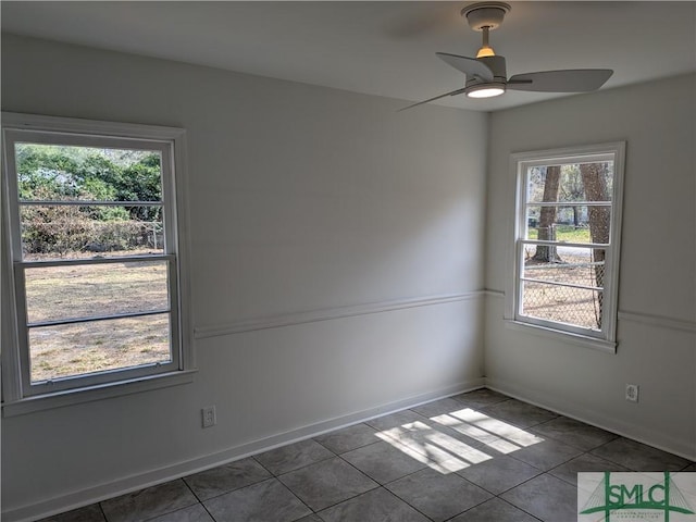 unfurnished room featuring tile patterned floors, baseboards, and a ceiling fan