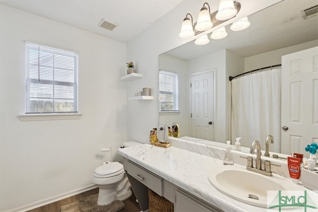 full bathroom featuring vanity, toilet, baseboards, and visible vents