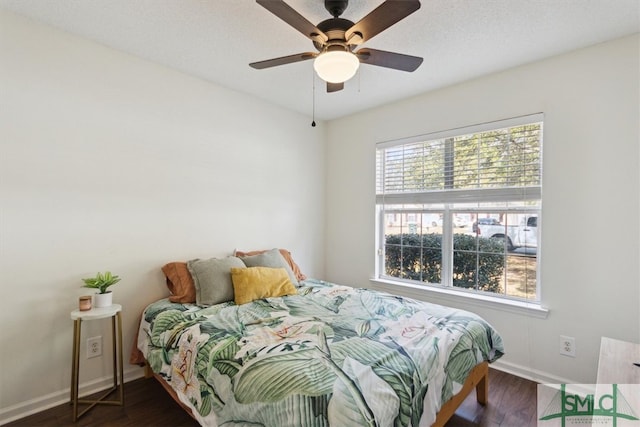 bedroom with dark wood-style floors, ceiling fan, and baseboards