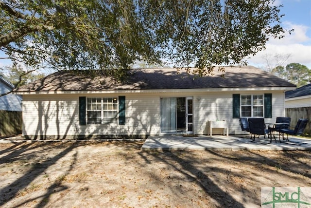 rear view of house featuring a patio and fence