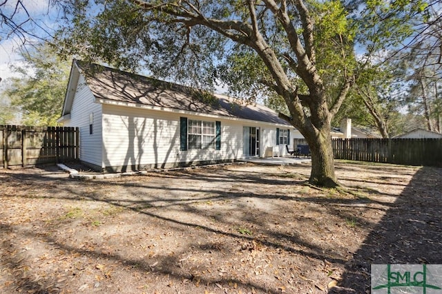 rear view of house featuring a patio area and fence