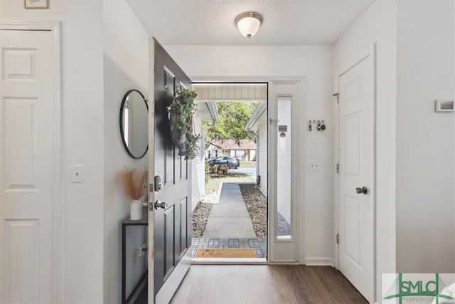 entryway featuring a textured ceiling and wood finished floors