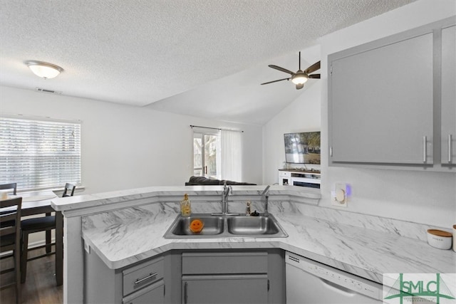 kitchen featuring gray cabinetry, light countertops, a peninsula, white dishwasher, and a sink