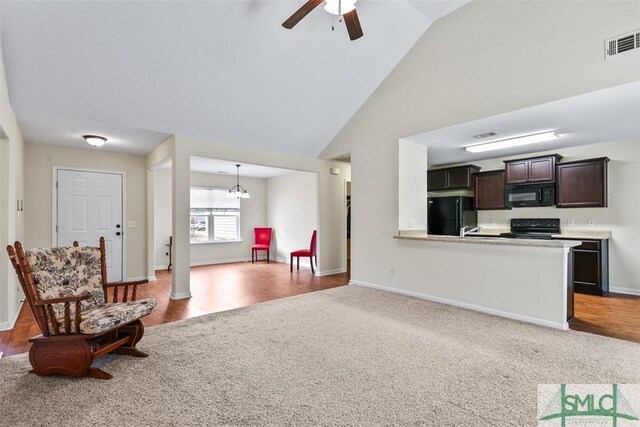 interior space with visible vents, high vaulted ceiling, ceiling fan with notable chandelier, wood finished floors, and baseboards