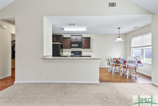 kitchen with dark brown cabinets, visible vents, black appliances, and light countertops