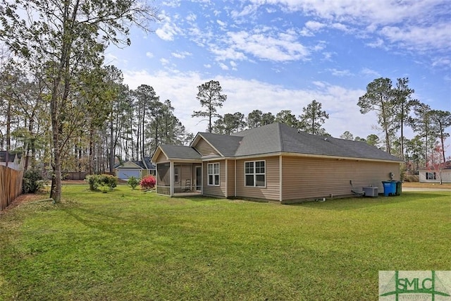 exterior space with fence, a lawn, and a sunroom