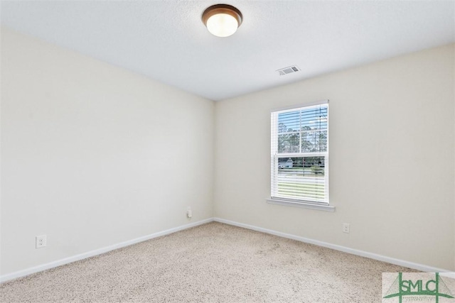 carpeted empty room with visible vents and baseboards