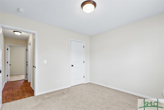 unfurnished bedroom with baseboards and carpet