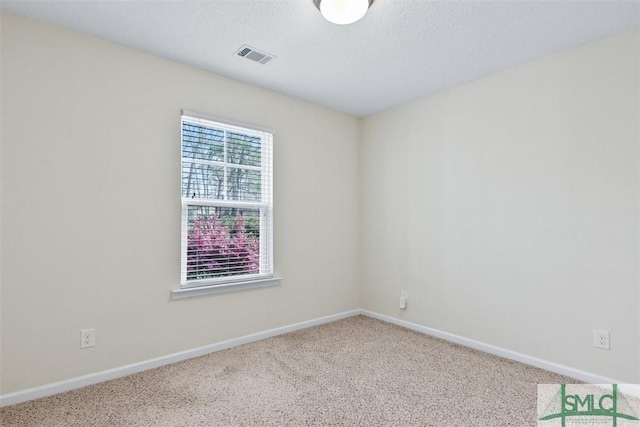 unfurnished room featuring visible vents, carpet floors, a textured ceiling, and baseboards