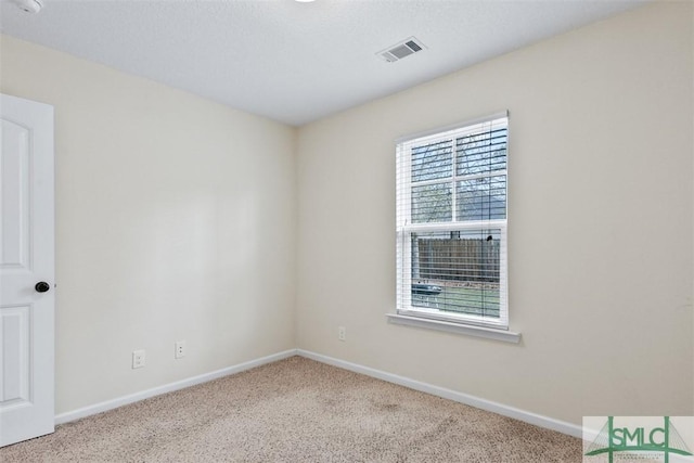 carpeted empty room with visible vents and baseboards