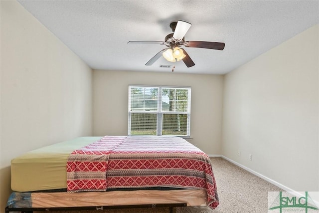 bedroom with carpet, visible vents, baseboards, ceiling fan, and a textured ceiling