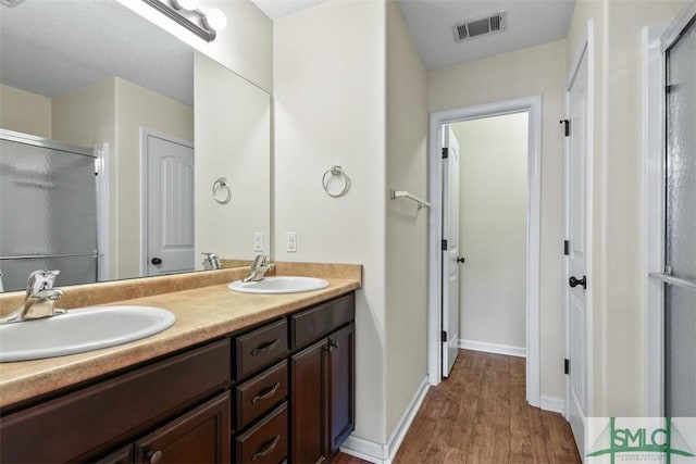 full bath with a stall shower, visible vents, and a sink