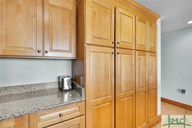 kitchen with light stone countertops and light brown cabinetry