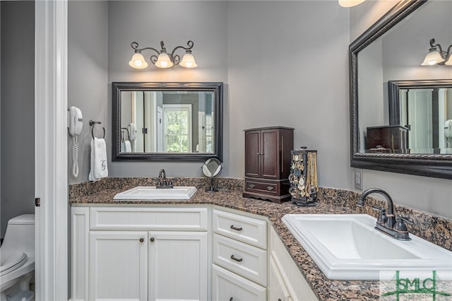 full bath with a sink, toilet, and double vanity