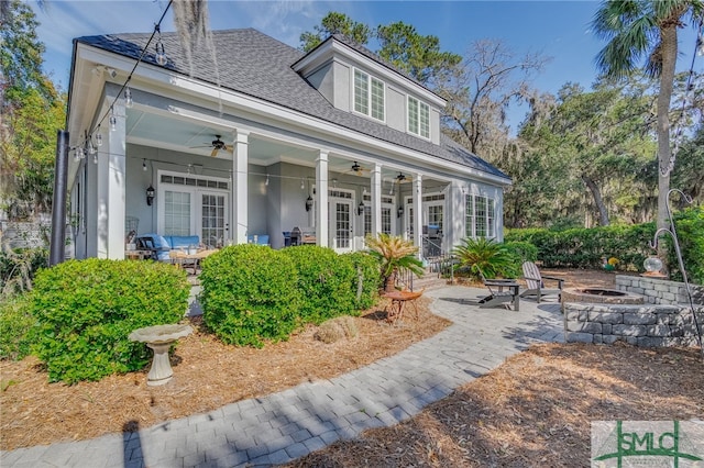 back of house featuring roof with shingles, an outdoor fire pit, stucco siding, ceiling fan, and french doors