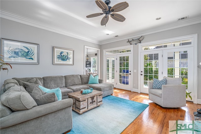 living room with visible vents, french doors, wood-type flooring, crown molding, and ceiling fan