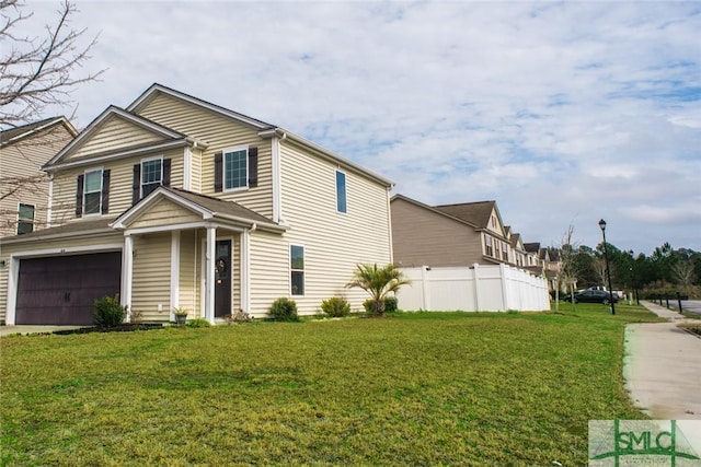 view of front facade featuring an attached garage, concrete driveway, a front yard, and fence