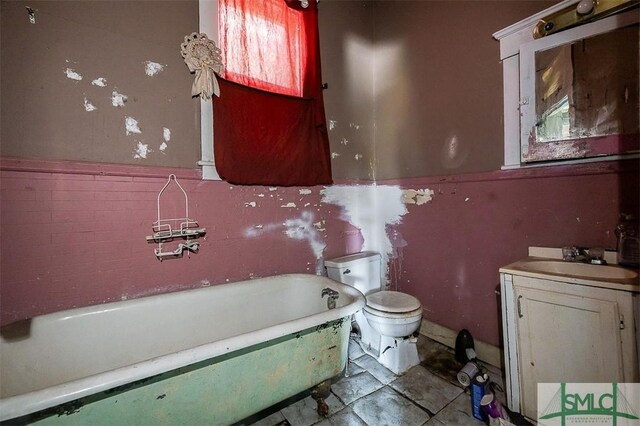 full bath with toilet, a tub to relax in, and vanity