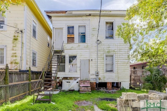 back of property featuring stairway and fence