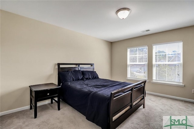 bedroom featuring visible vents, light colored carpet, and baseboards